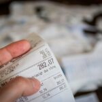 Cartella esattoriale con avviso di blocco pagamenti e simboli di attenzione.